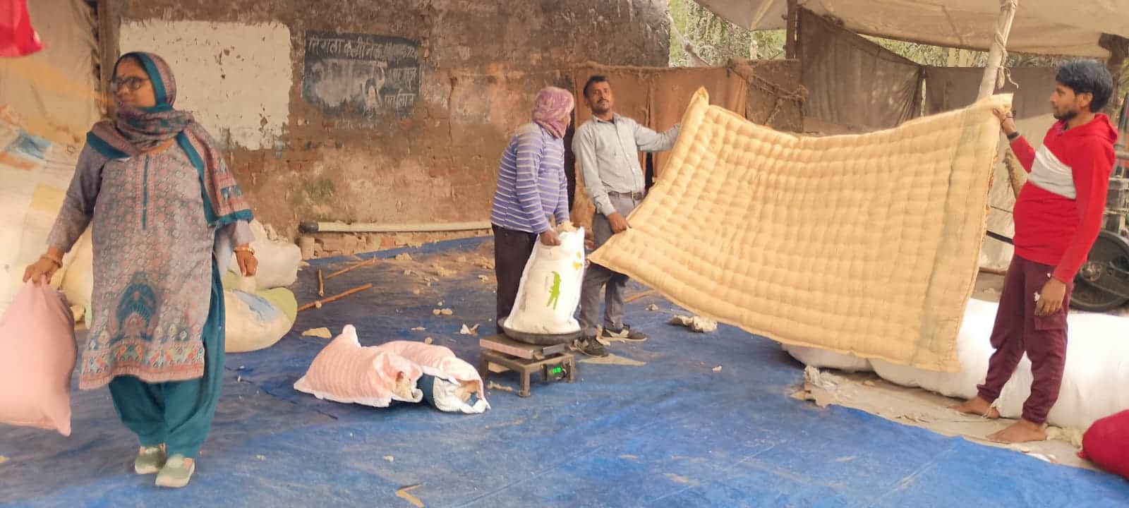 भाड़ावास मार्ग पर ग्राहक को रजाई दिखाते कारीगर। संवाद