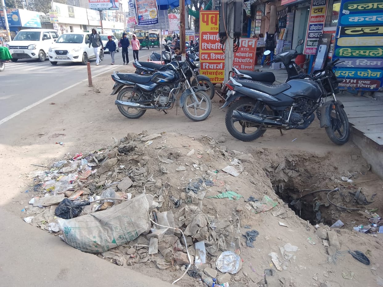 The tile-laying work on the service road, which had been stalled for a long time, is causing problems for shopkeepers.