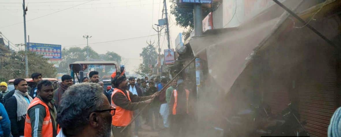 फुटपाथ से अतिक्रमण हटाते पालिका कर्मी।