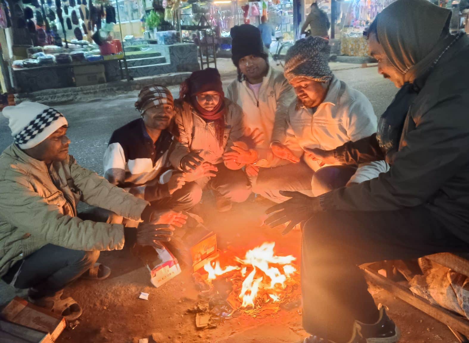  कुड़वार कस्बे में कागज जलाकर अलाव तापते लोग। संवाद