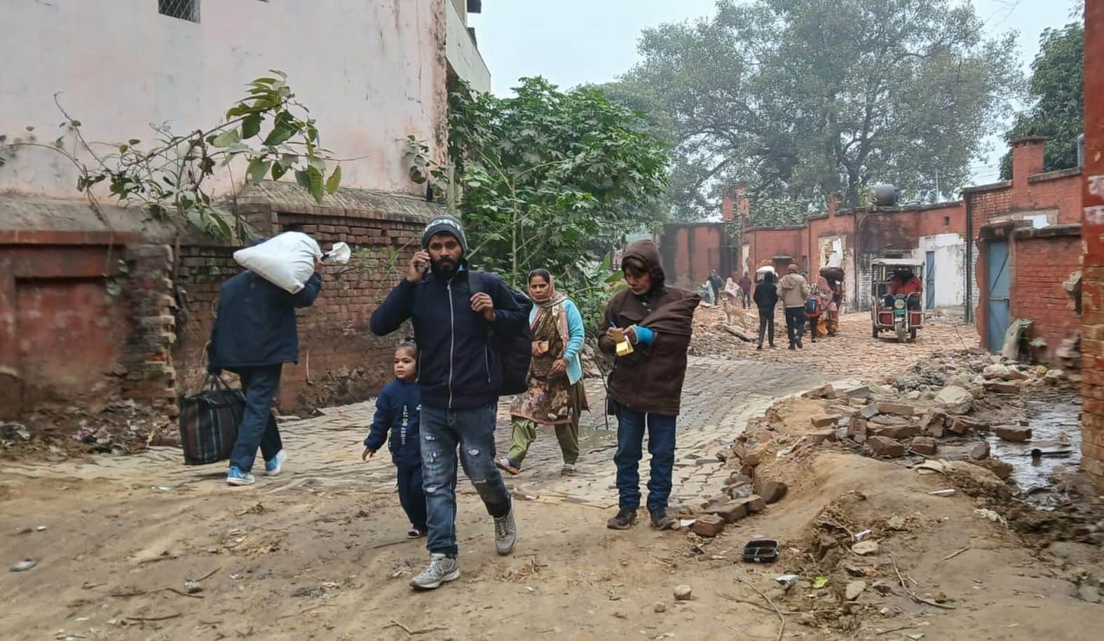 सुल्तानपुर रेलवे स्टेशन जाने के लिए बनाए गए वैकल्पिक मार्ग पर गड्ढों से गुजरते यात्री। 