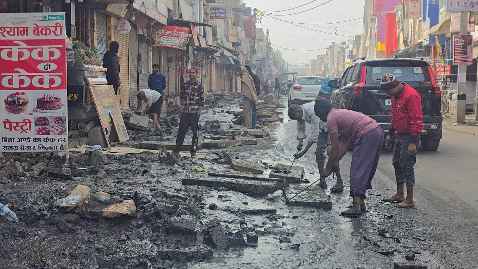 07jjrp13- झज्जर। आंबेडकर चौक पर मजदूर बुलाकर दुकान के सामने सफाई कराते दुकानदार। संवाद