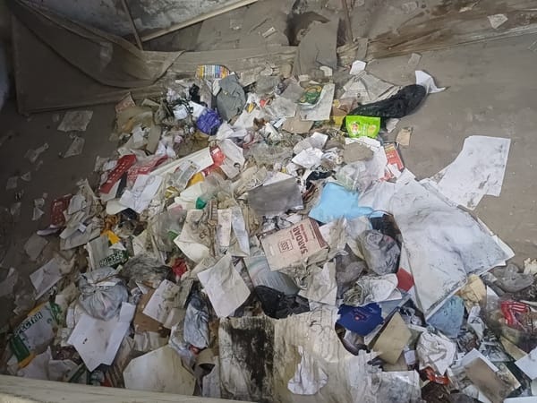 Piles of garbage in the subdivision building, cleaning system with the help of two employees