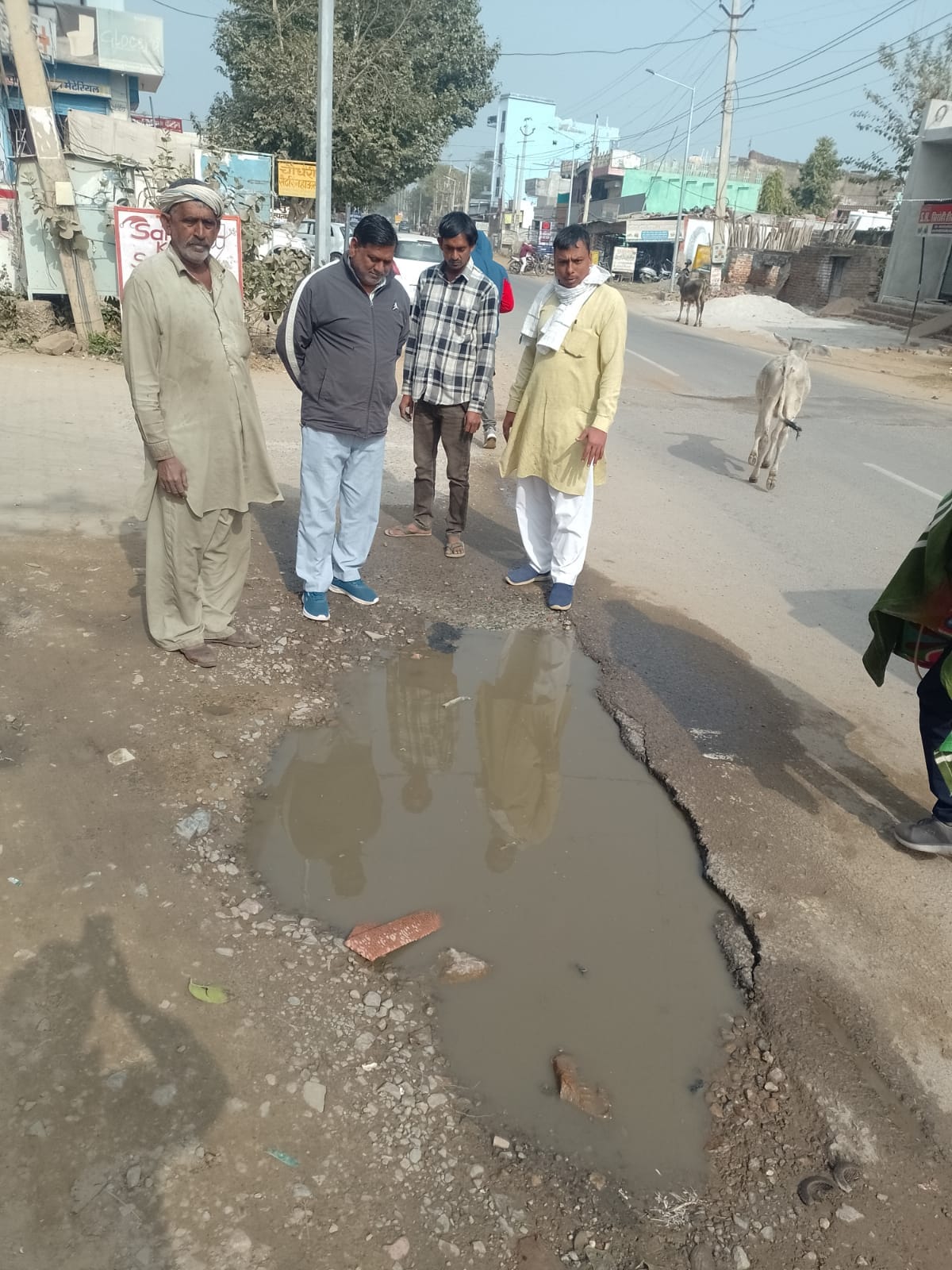 Deep potholes on the road are causing problems for pedestrians.