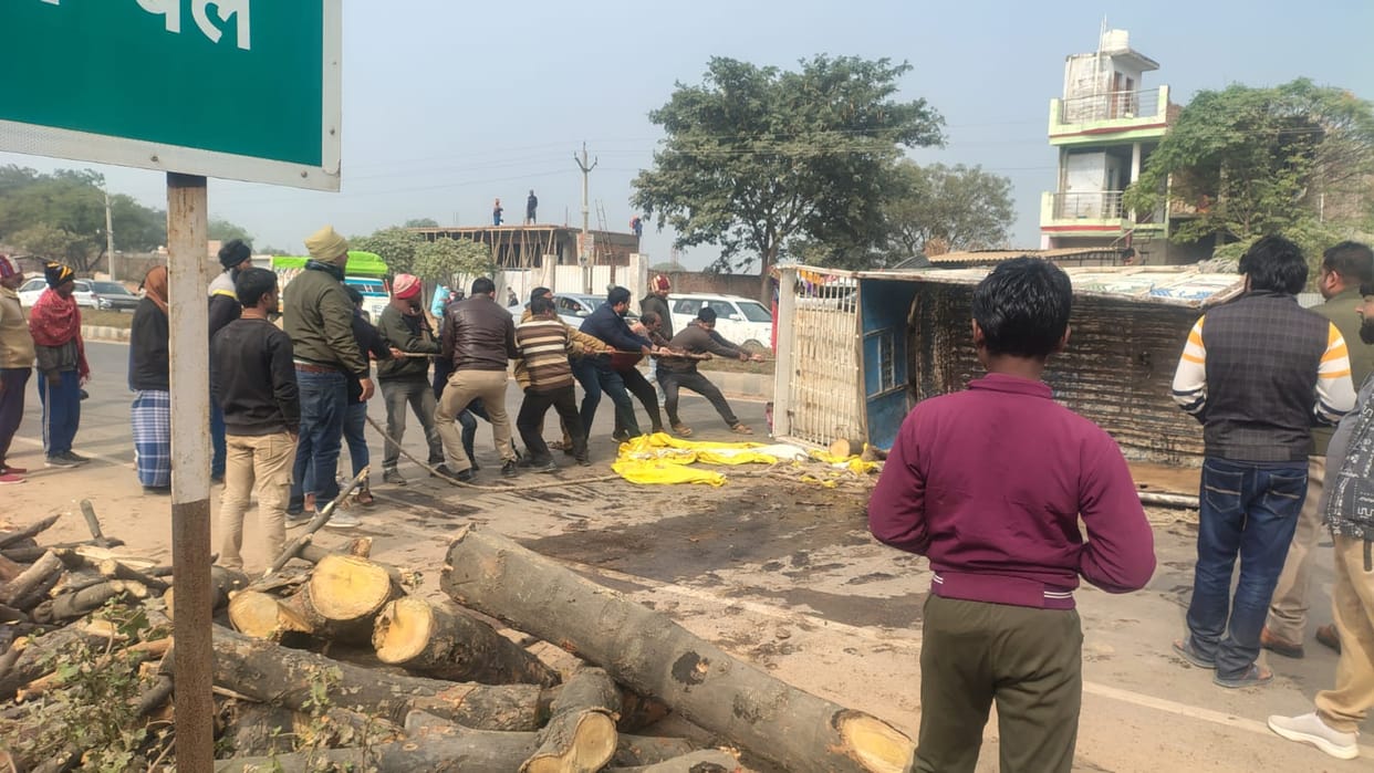 Pickup loaded with wood overturned, worker injured