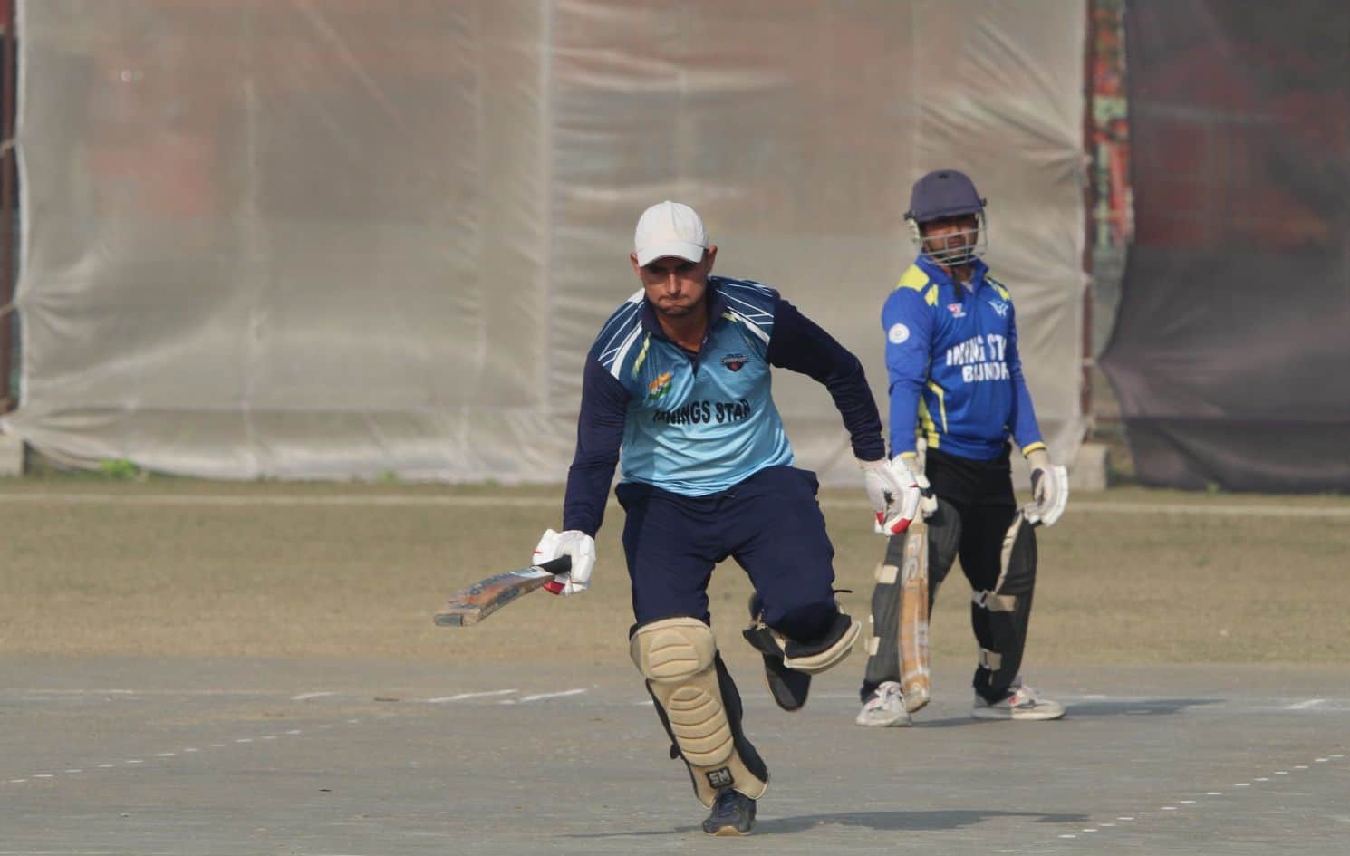 लॉर्ड्स बालाजी के ए-ग्राउंड पर शाॅट मारने के बाद रन बनाने के लिए दौड़ लगाते खिलाड़ी।