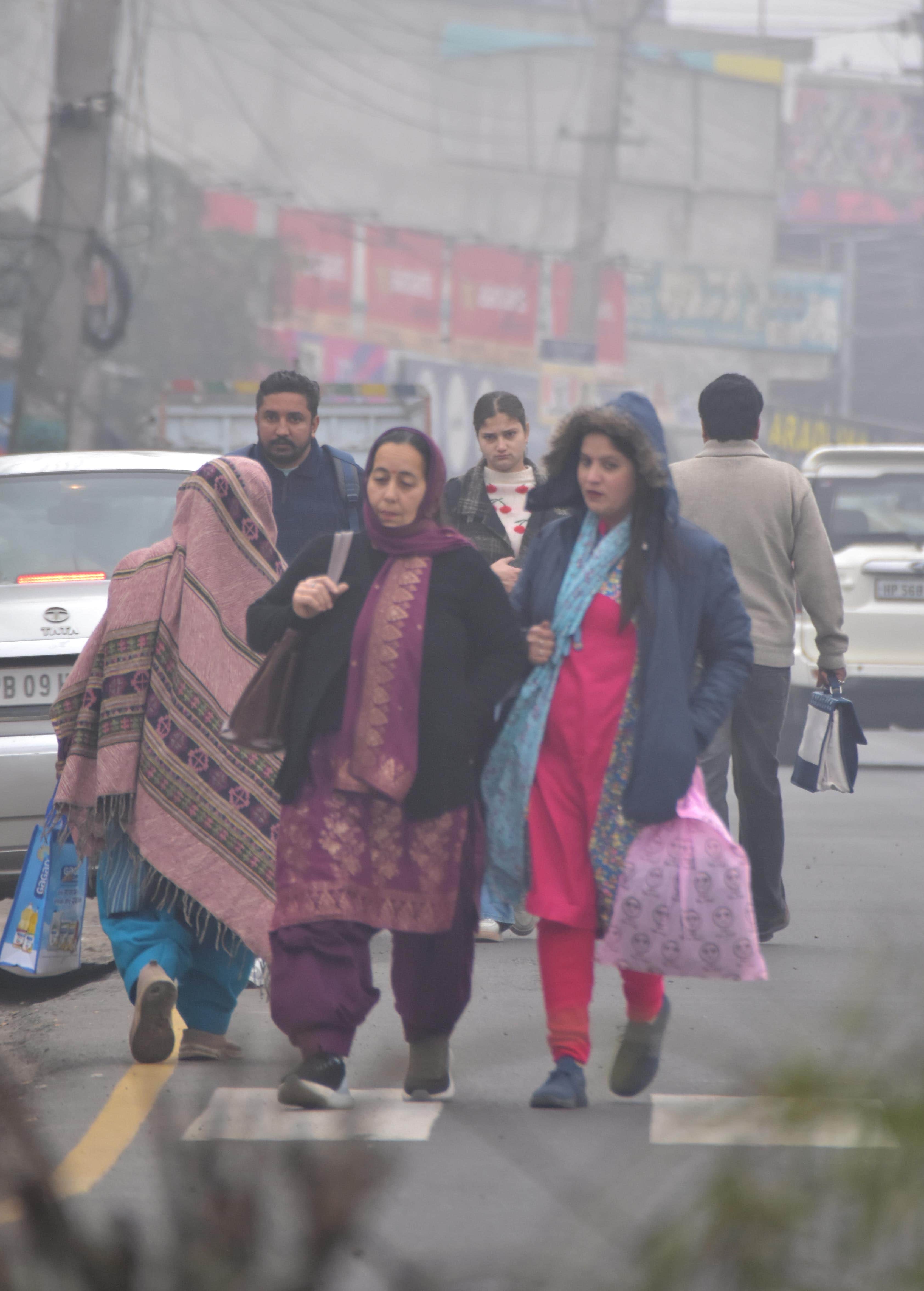 ऊना में सुबह के समय घने कोहरे के बीच गंतव्य की और जाती महिलाएं ।संवाद