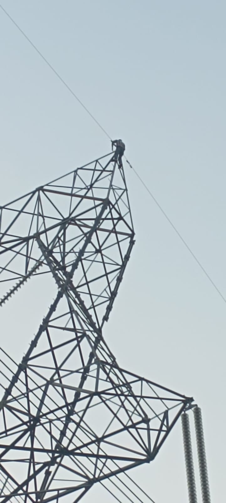 Drunk man climbs high tension line tower