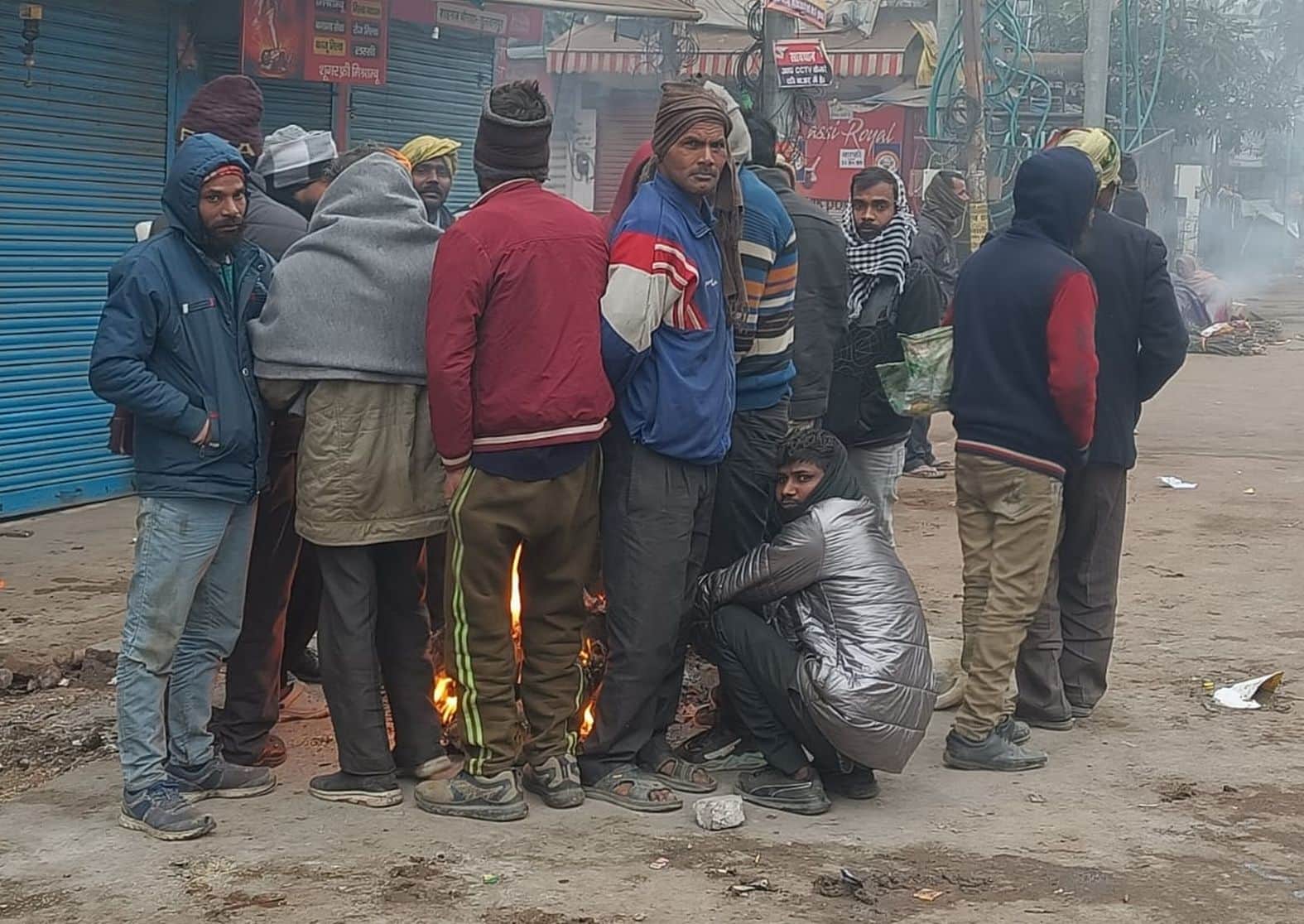 शहर के शाहगंज चौराहे पर शुक्रवार सुबह अलाव के पास खड़े मजदूर। संवाद