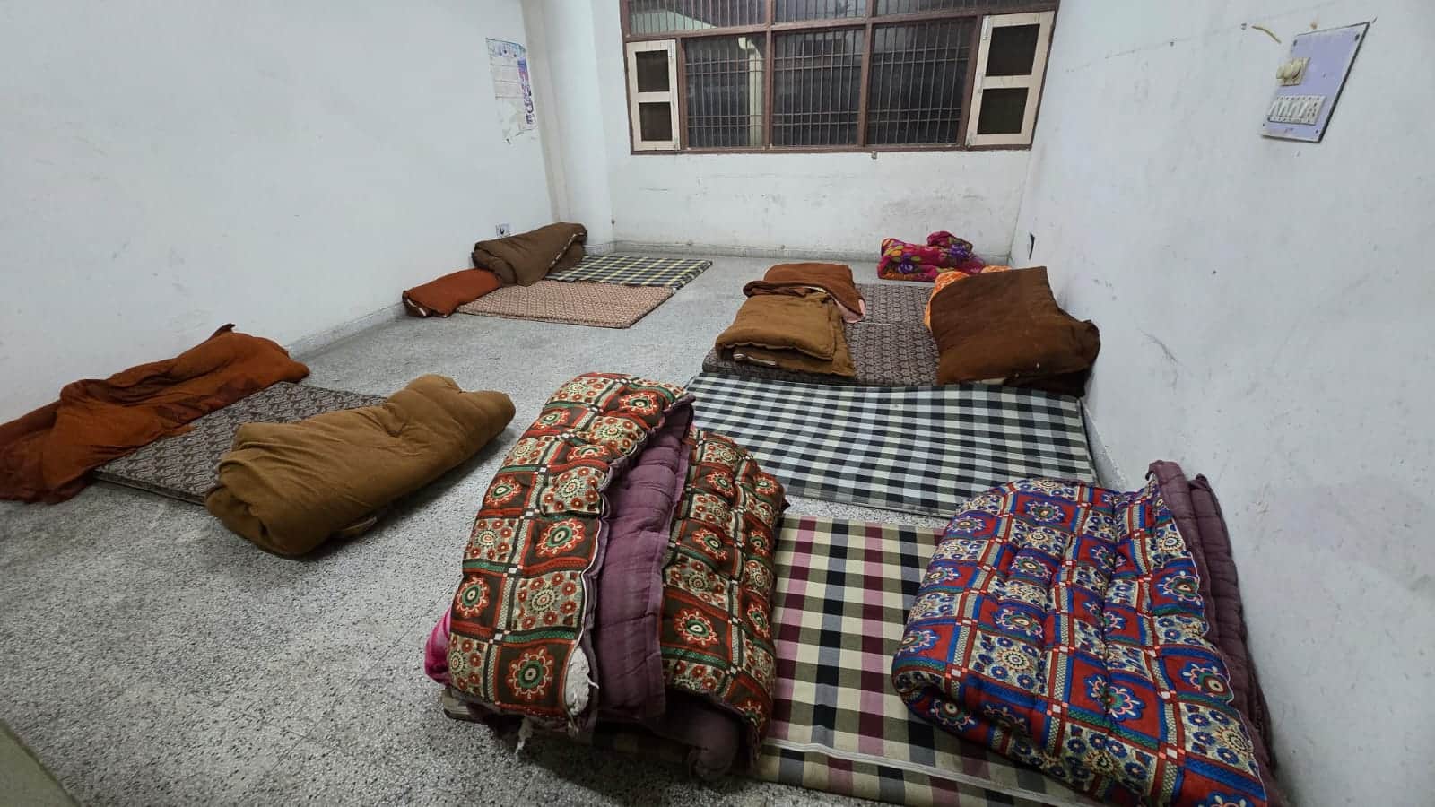 11jjrp05- बस अड्डे पर बने रैन बसेरे में जमीन पर बिछाए गए गद्दे व रखी रजाईयां। संवाद