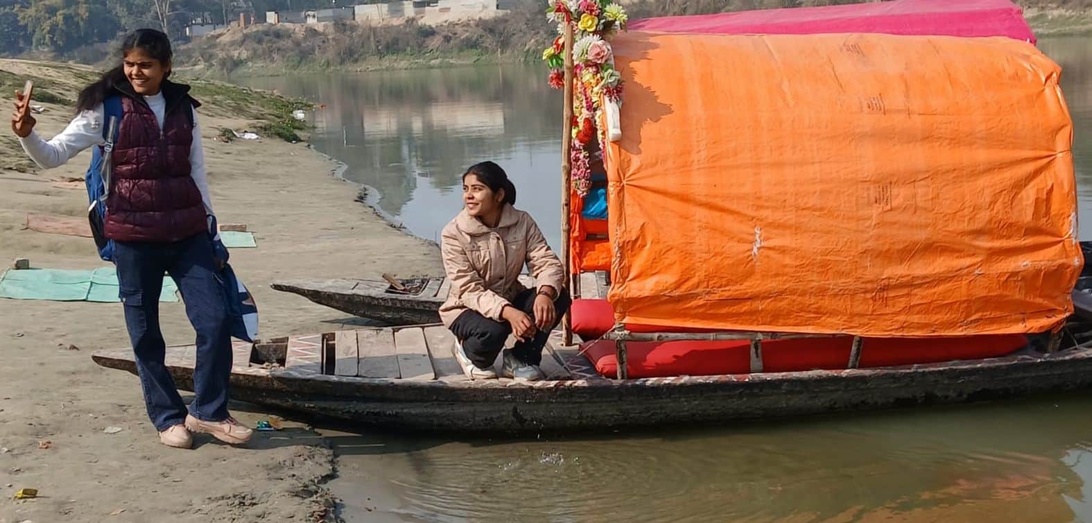 सीताकुंड धाम स्थित गोमती नदी के तट पर नाव में सेल्फी लेतीं युवतियां।