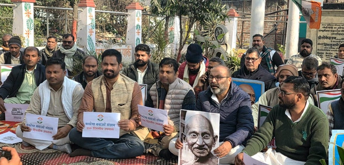 Congress members stage a protest in front of the Gandhi statue.