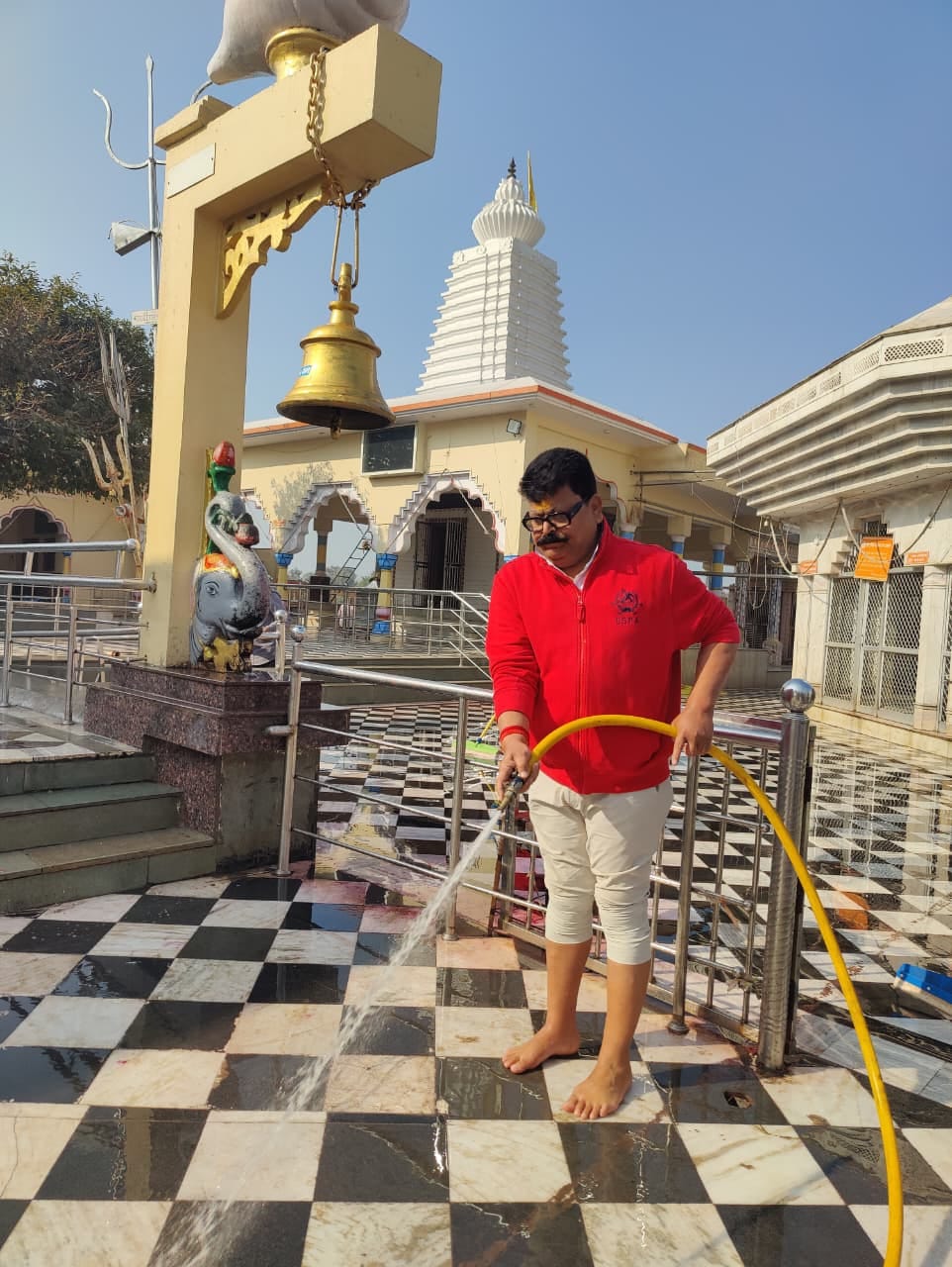 मंदिर परिसर में सफाई करते नगर पालिका अध्यक्ष पप्पू मलिक