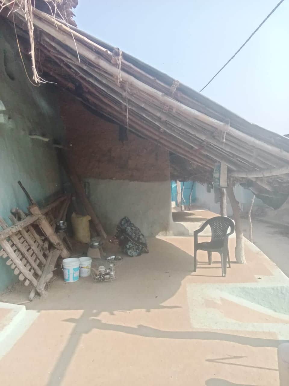 फोटो - 02 घर में लगा पन्नी का तंबू और कार्य करतीं पीड़िता। संवाद