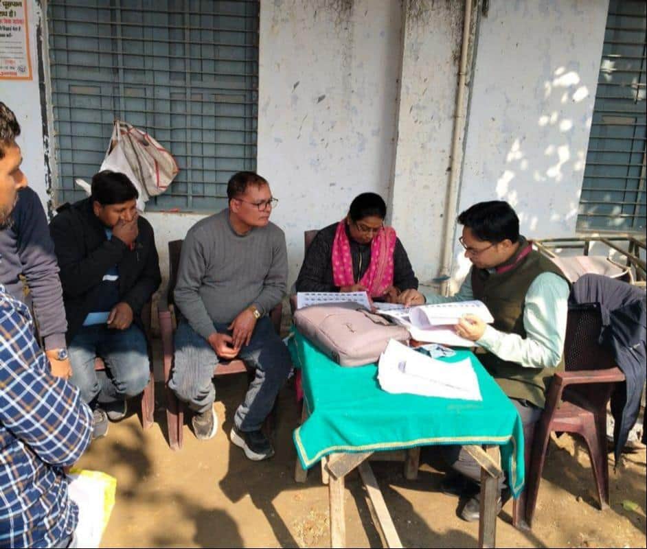 फोटो-2-पोलिंग बूथ पर बीएलओ की मौजूदगी में सूची में नाम देखते वोटर। आर्काइव।