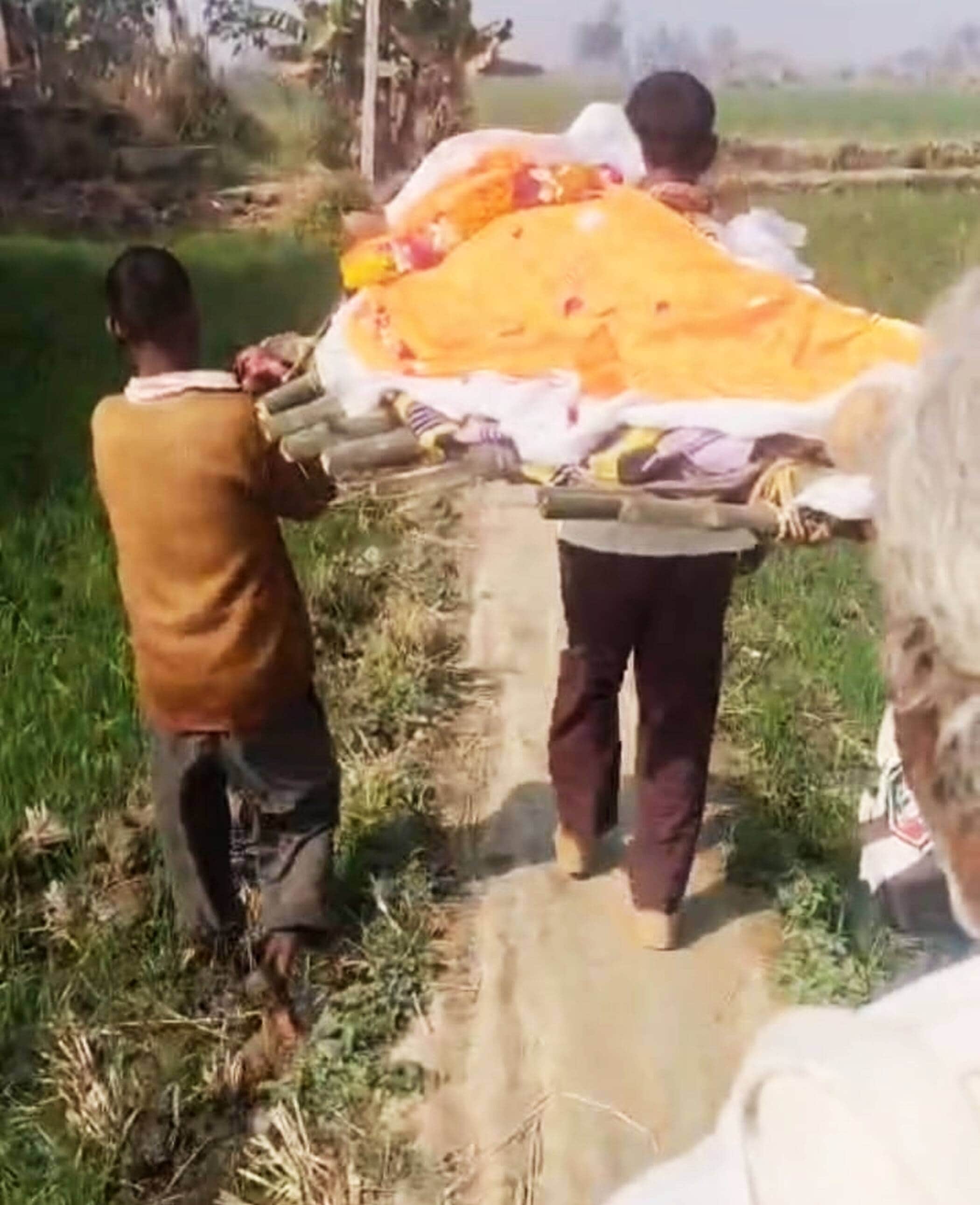 फोटो-19-गेहूं की फसल में पानी भरे खेत से अंतिम संस्कार के लिए शव ले जाते ग्रामीण। संवाद