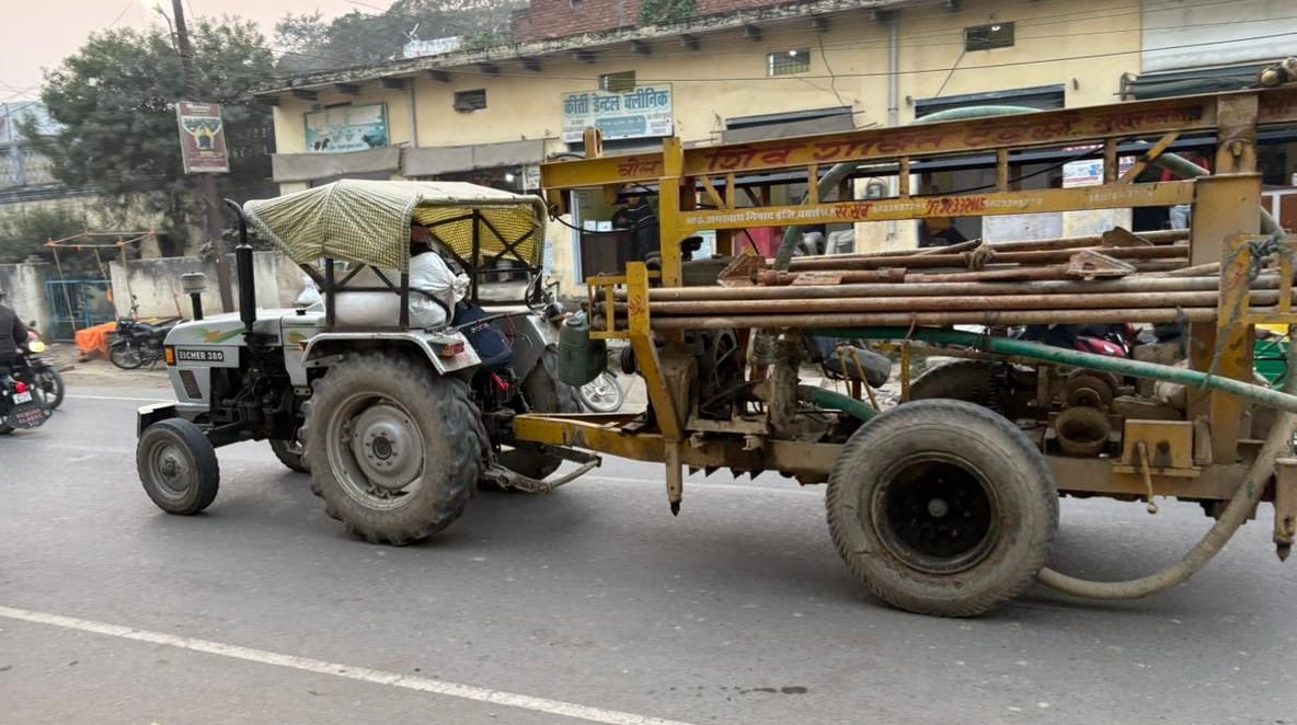 Registered agricultural tractors transport soil, sand, cement, and tent materials.