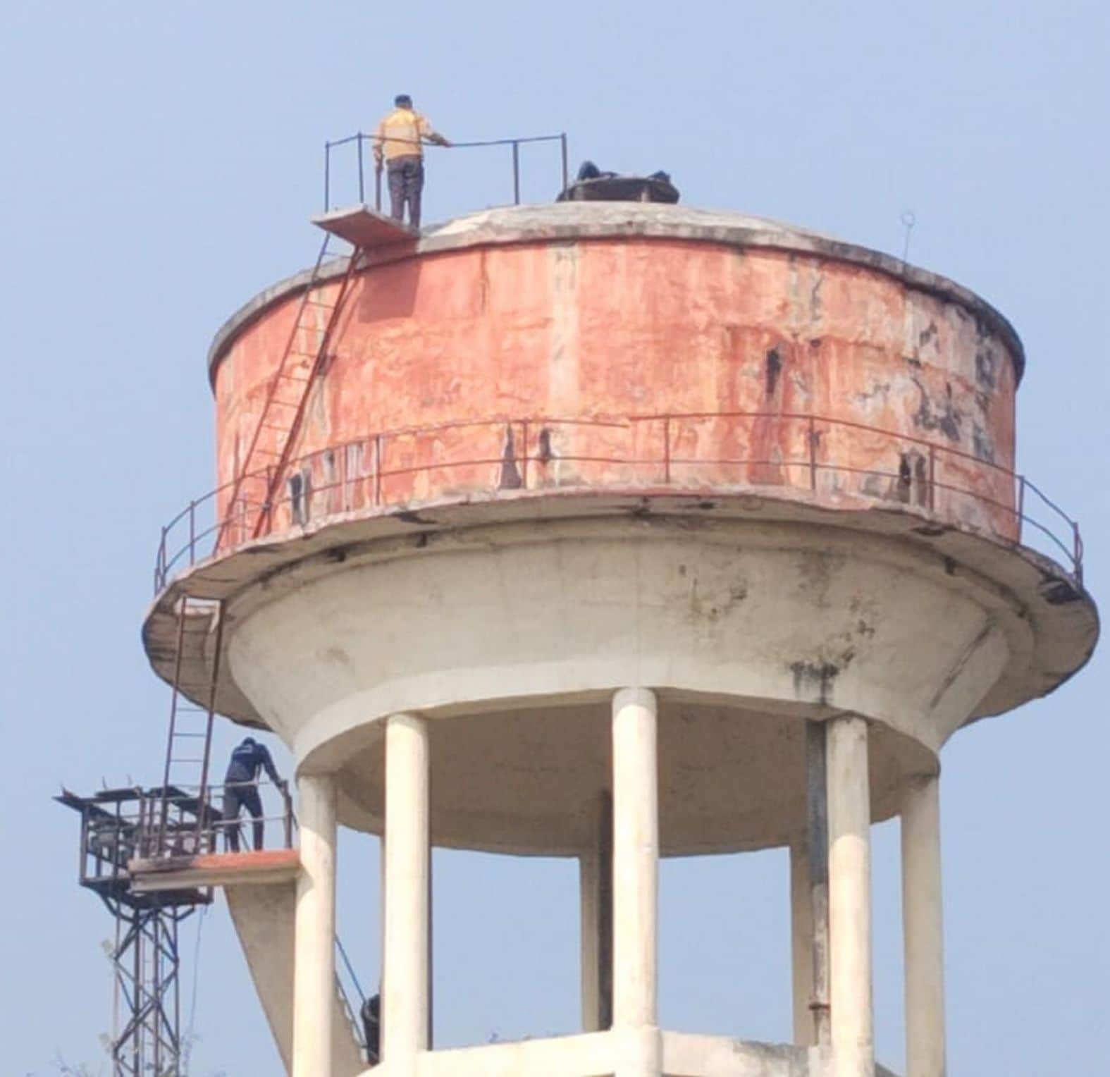 . रेलवे स्टेशन यार्ड के टीआरडी सेक्शन के पास पानी की टंकी पर लेटा युवक। संवाद