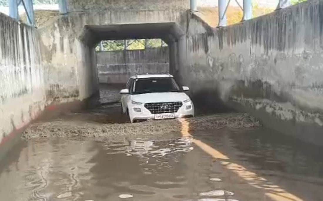 फोटो-1-कानपुर-बालामऊ रेलमार्ग पर बने अंडरपास में भरे पानी से निकलता कार सवार। संवाद