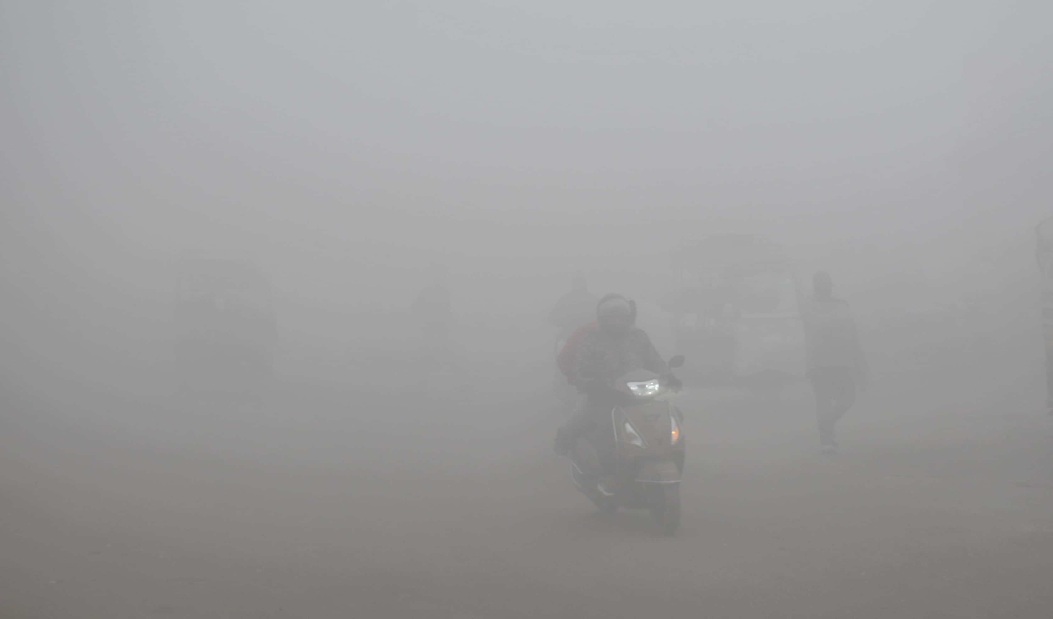 घने कोहरे में रेंगते वाहन।