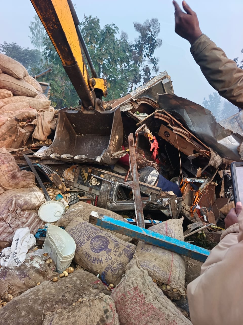 Potato-laden truck overturns in ditch, driver trapped in cabin