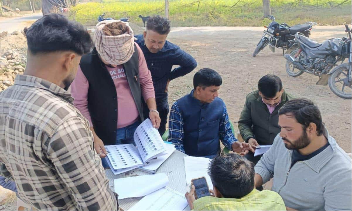 फोटो-32-झलोतर प्राथमिक विद्यालय के बूथ पर वोटर लिस्ट में नाम ढूंढते मतदाता। संवाद