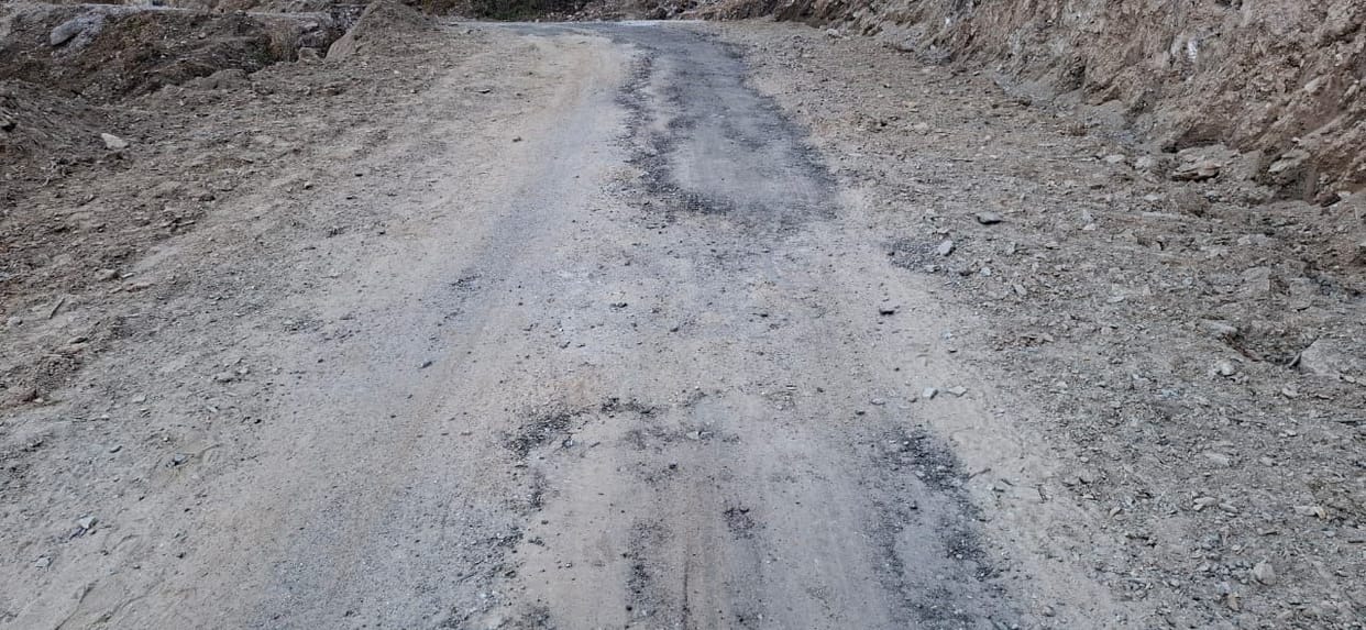 The asphalt on the Madkot-Tomik road has worn away within two years, angering villagers.
