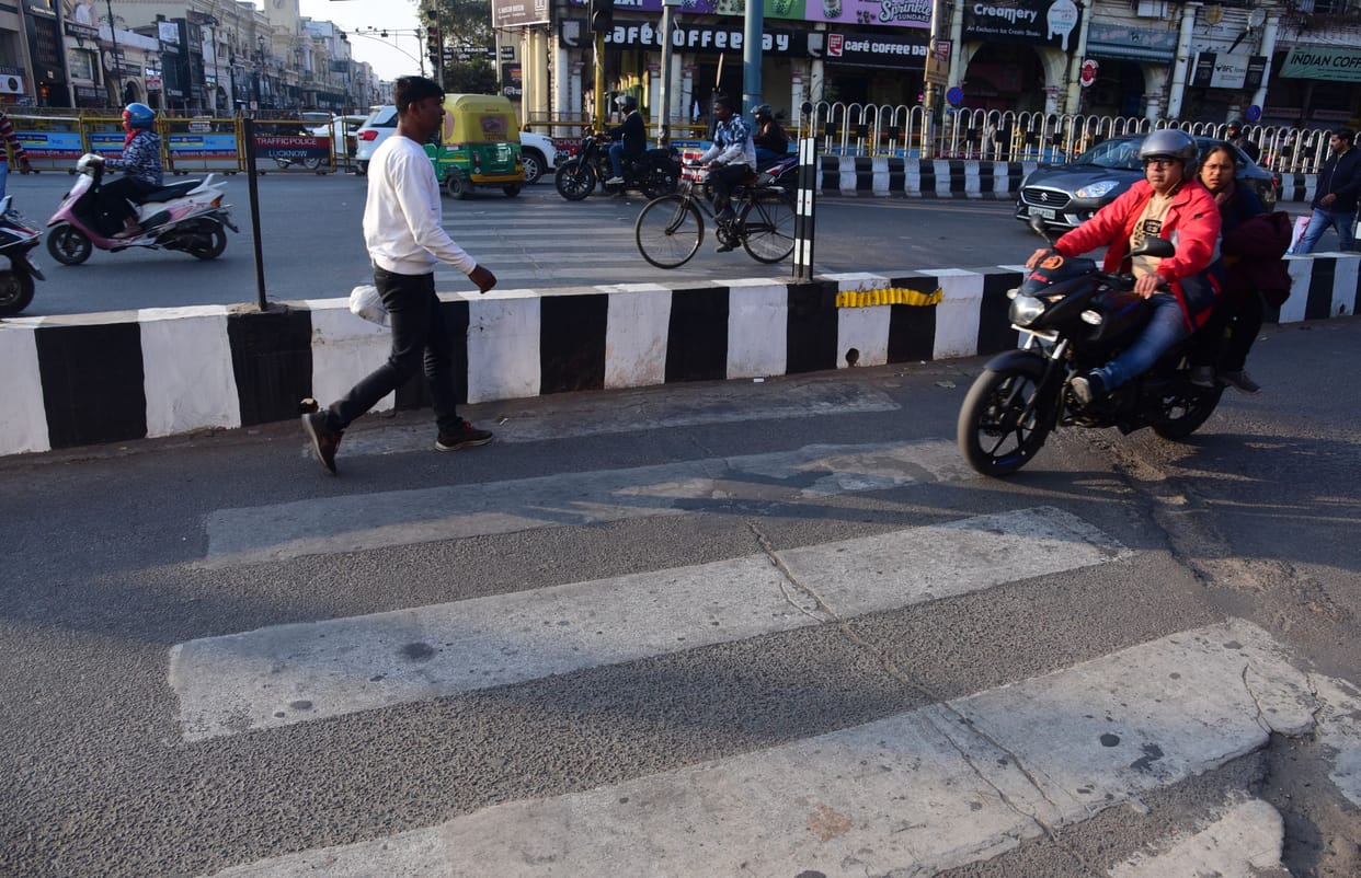 Zebra crossings are barricaded, red lights are overtaking stop lines, how are pedestrians supposed to cross the road?