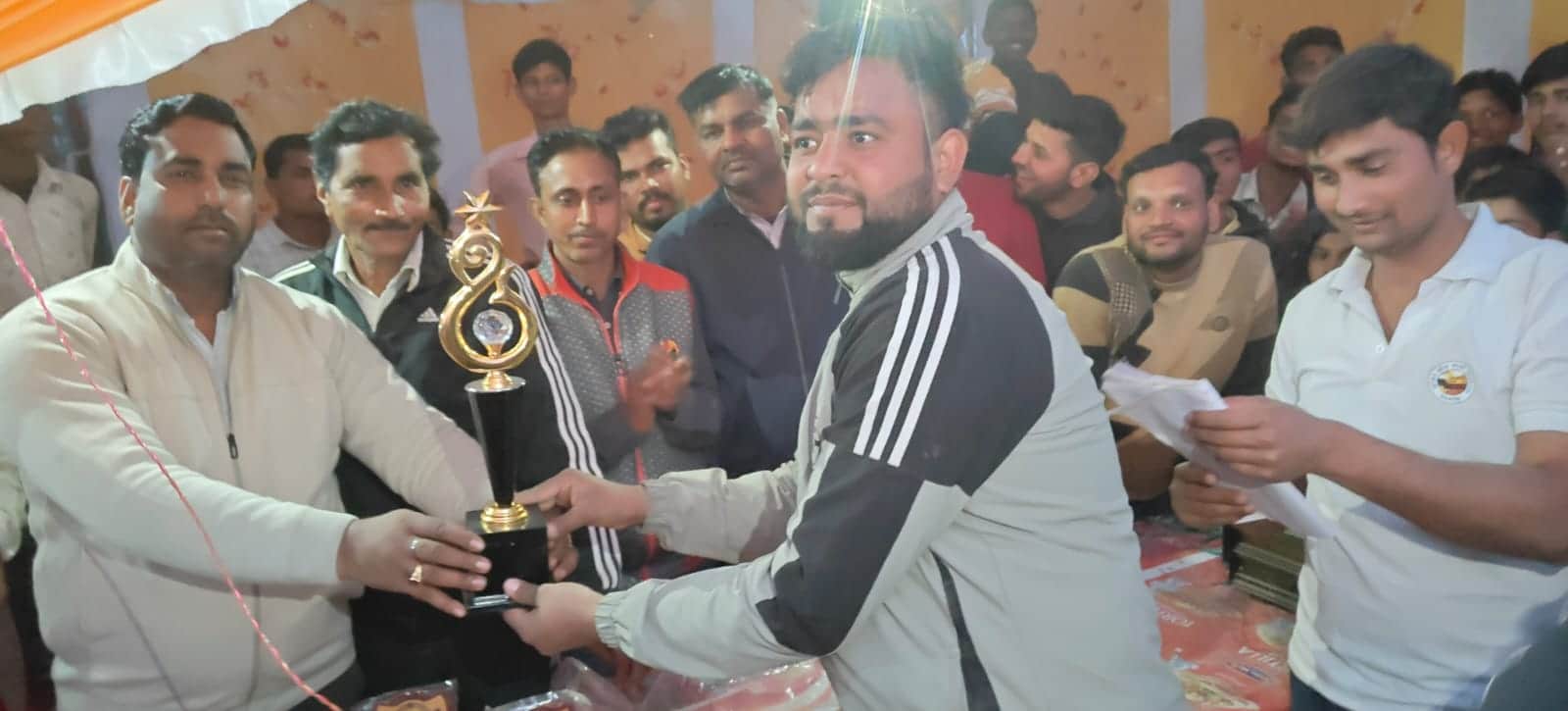 कलान में विजेता टीम के कप्तान को ट्राॅफी देते पूर्व प्रधान पुष्पेंद्र। स्रोत: जागरूक पाठक