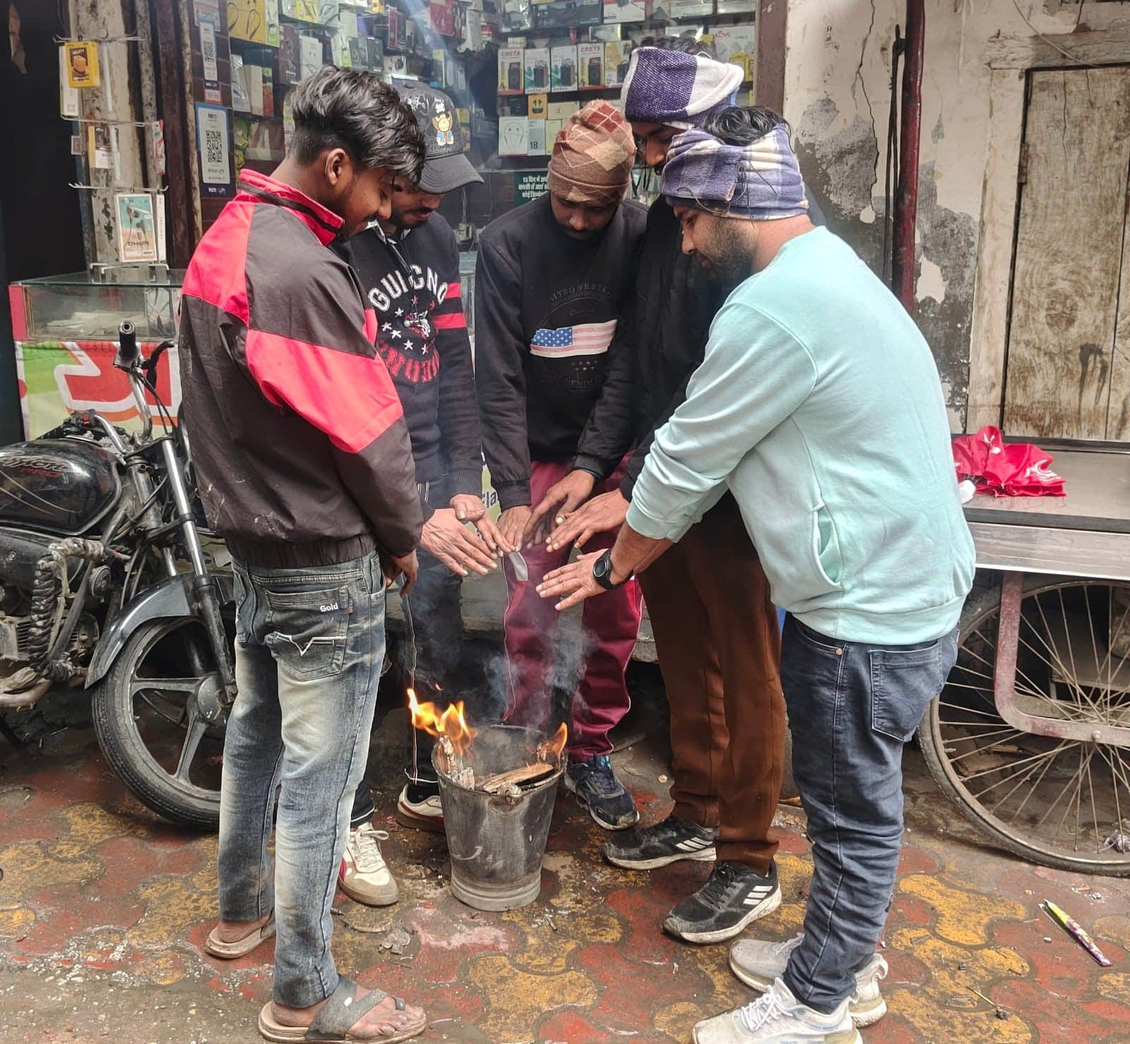 गुलावठी में ठंड से बचने के लिए अलाव का सहारा लेते लोग। संवाद