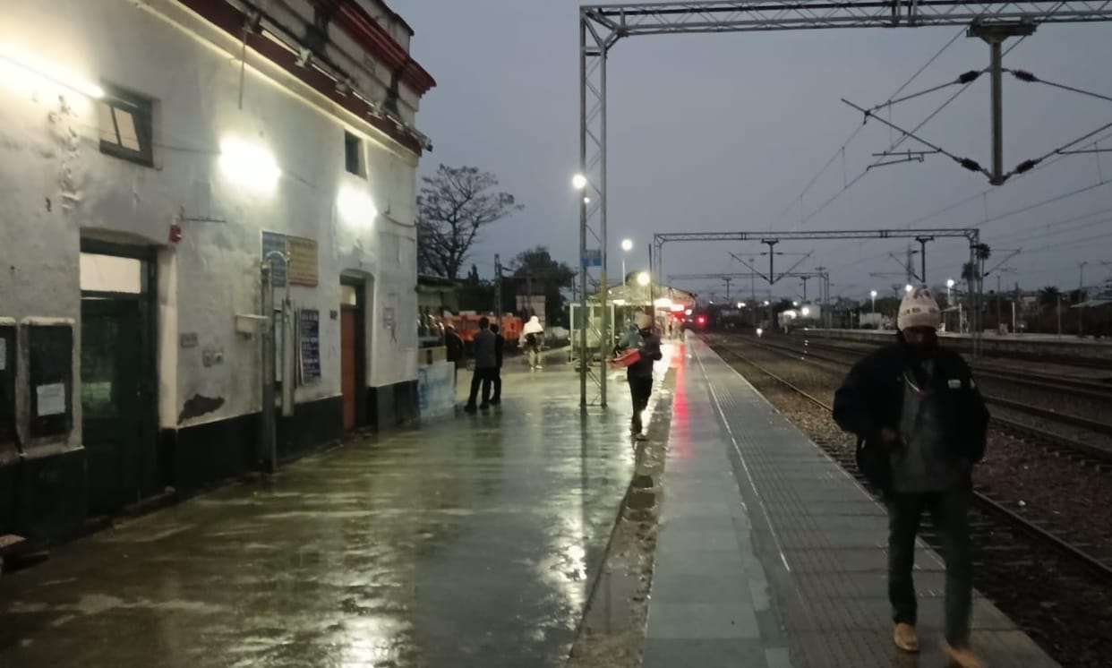 Passengers wait for the train under the open sky.