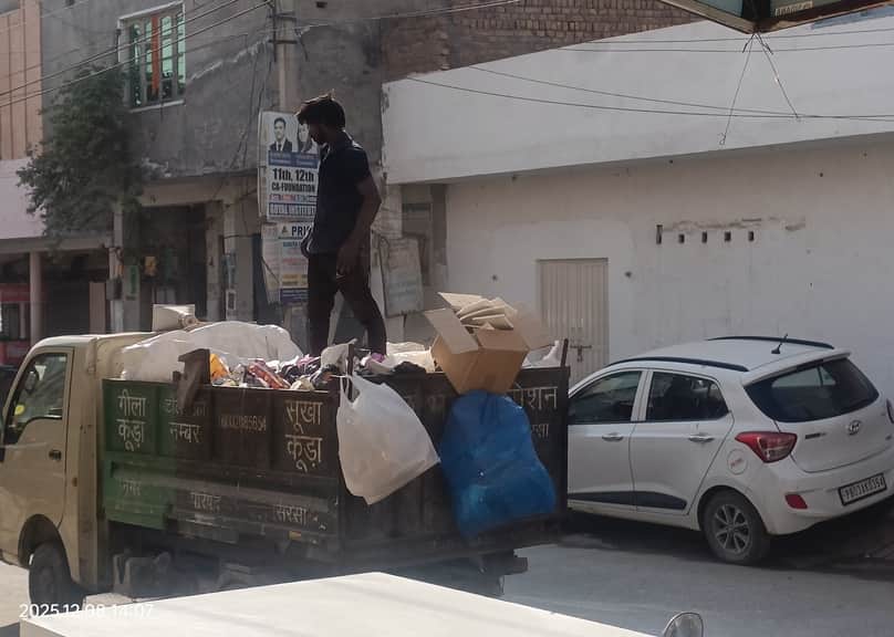 सिरसा। गाड़ी में कचरा उठाते हुए कर्मचारी। संवाद