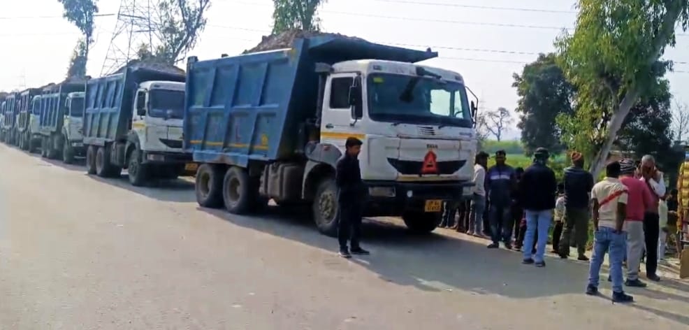 Villagers, troubled by the dust rising from the highway, stopped the construction company's dump trucks.