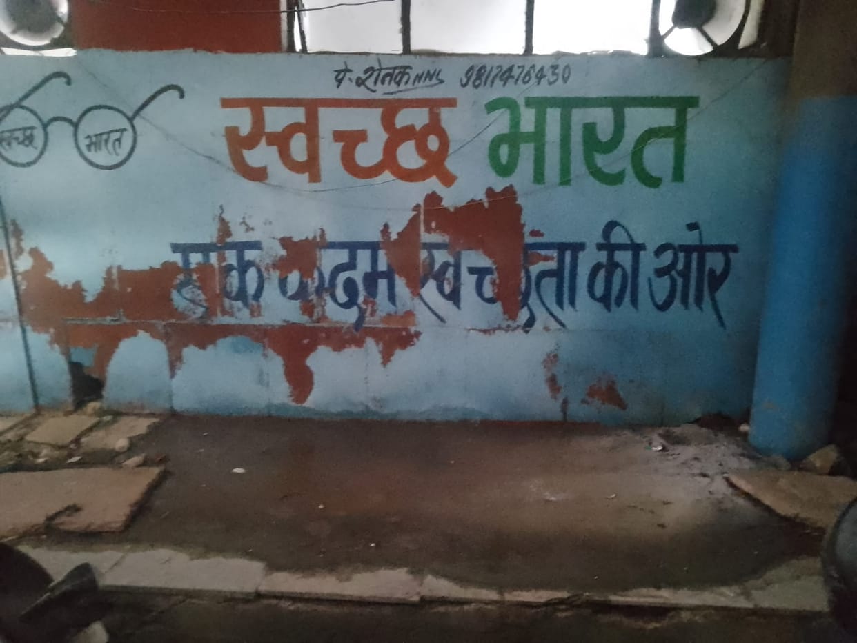 The most dirt is near the Swachh Bharat slogan.