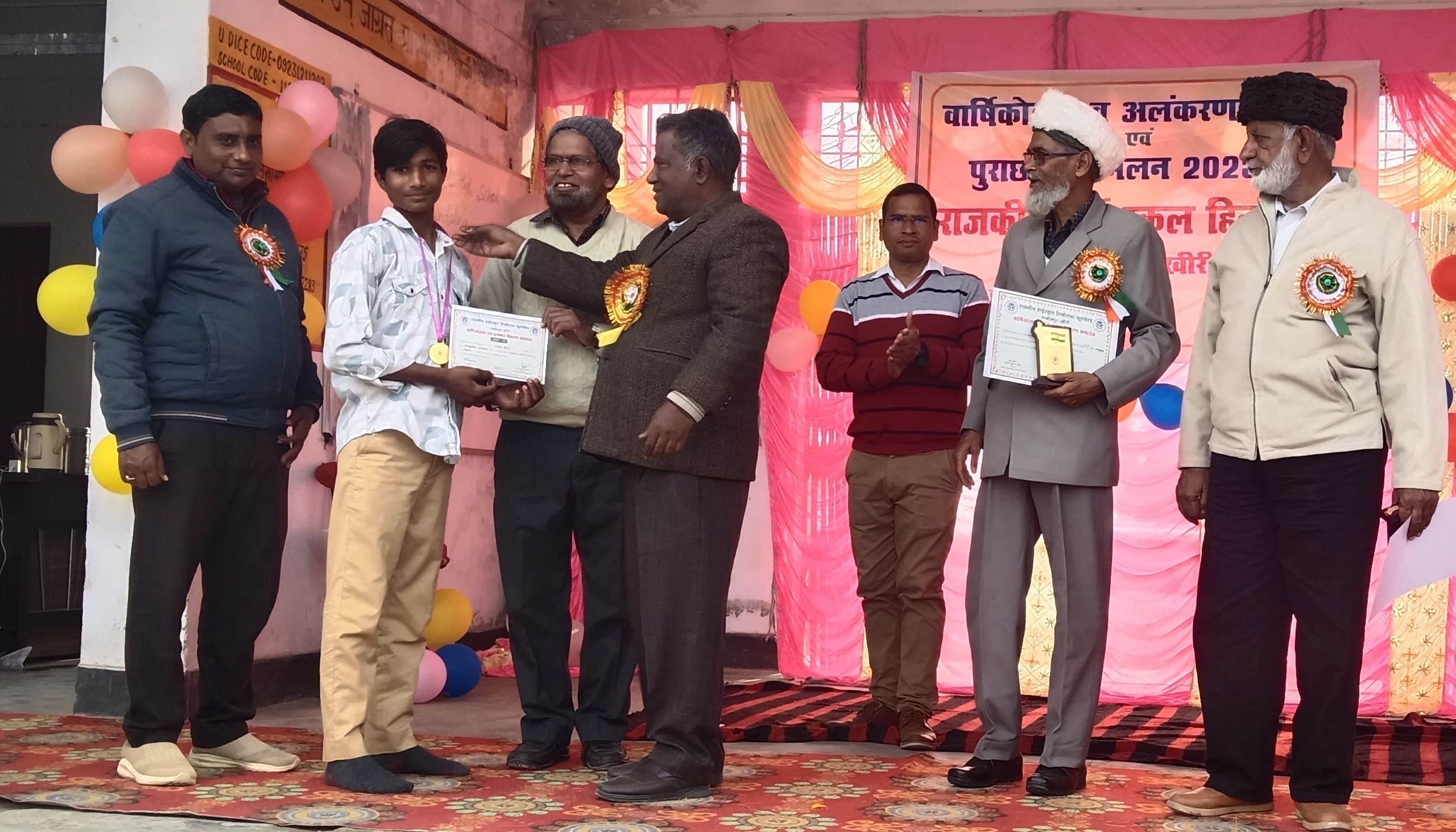 जूनियर हाई स्कूल हिंडोला में छात्र को सम्मानित करते शिक्षक। स्रोत: स्कूल