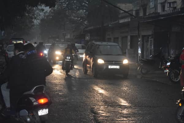 शनिदेव मार्ग पर बारिश के बीच जाते वाहन चालक व राहगीर। संवाद