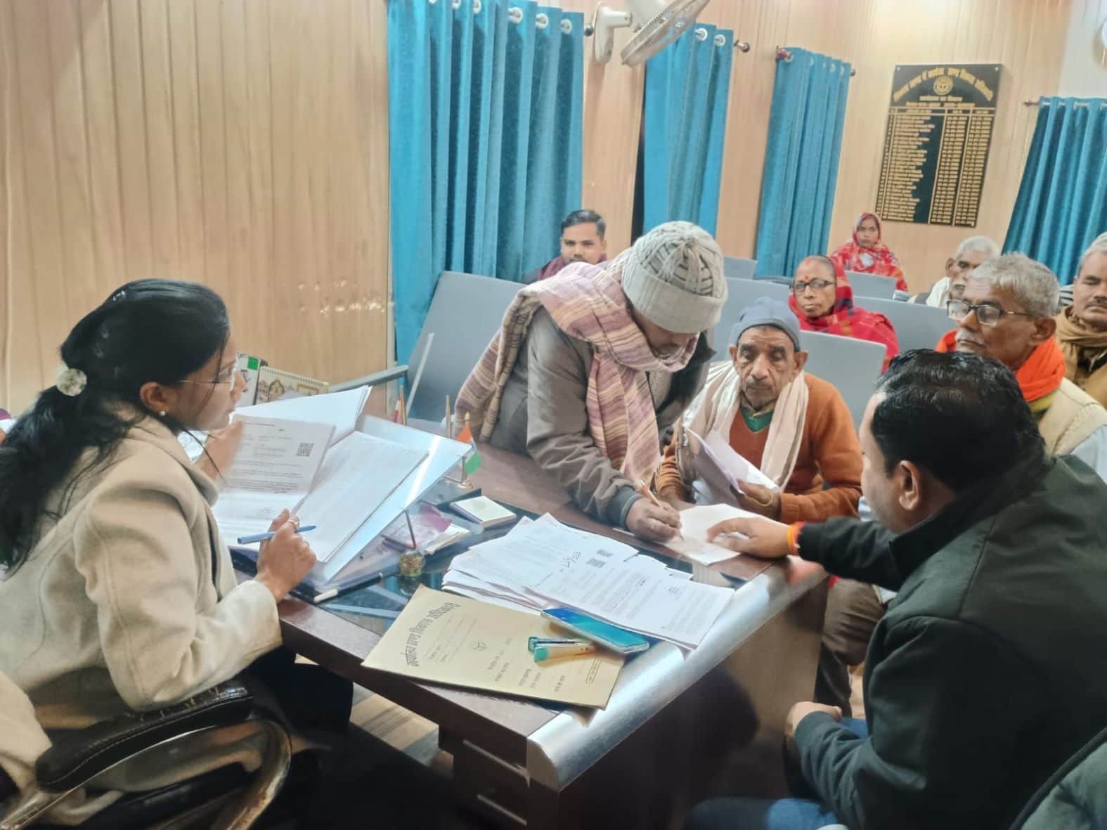 कुड़वार में नोटिस की सुनवाई करतीं सहायक पंजीकरण अधिकारी व मौजूद लोग। संवाद