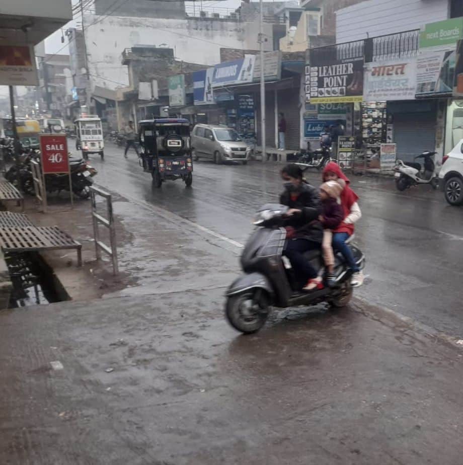 मंगलवार शाम को बूंदाबांदी के साथ स्कूटी से जाती युवती। संवाद