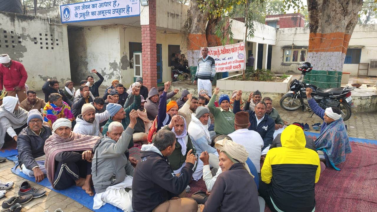 धरने पर बैठे कौशल निगम के कर्मचारी।