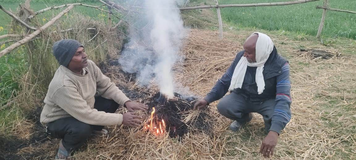 बूंदाबांदी के बाद बढ़ी ठंड के बाद अलाव तापते लोग। 