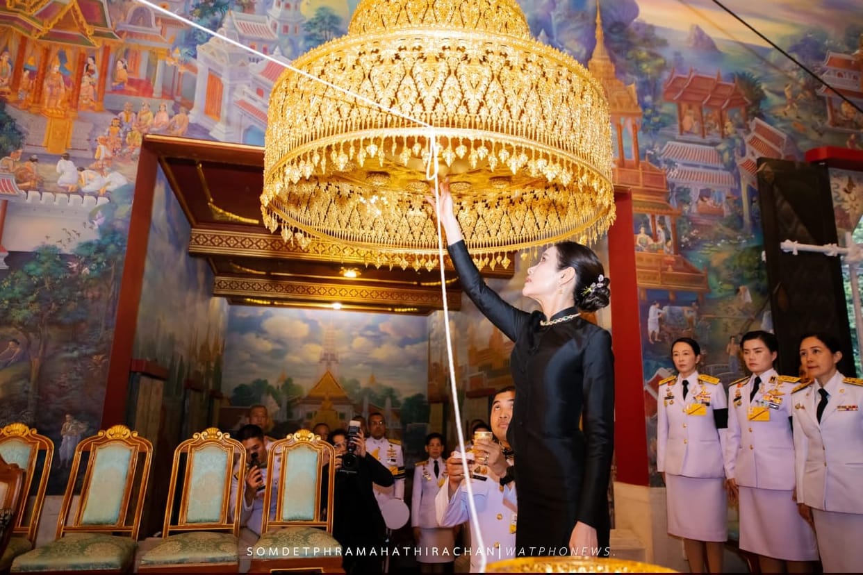 The Queen of Thailand offered an umbrella to the Buddha statue