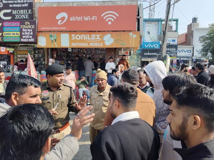 फतेहाबाद के मोबाइल मार्केट में दुकानदारों को निर्देश देते हुए संवाद
