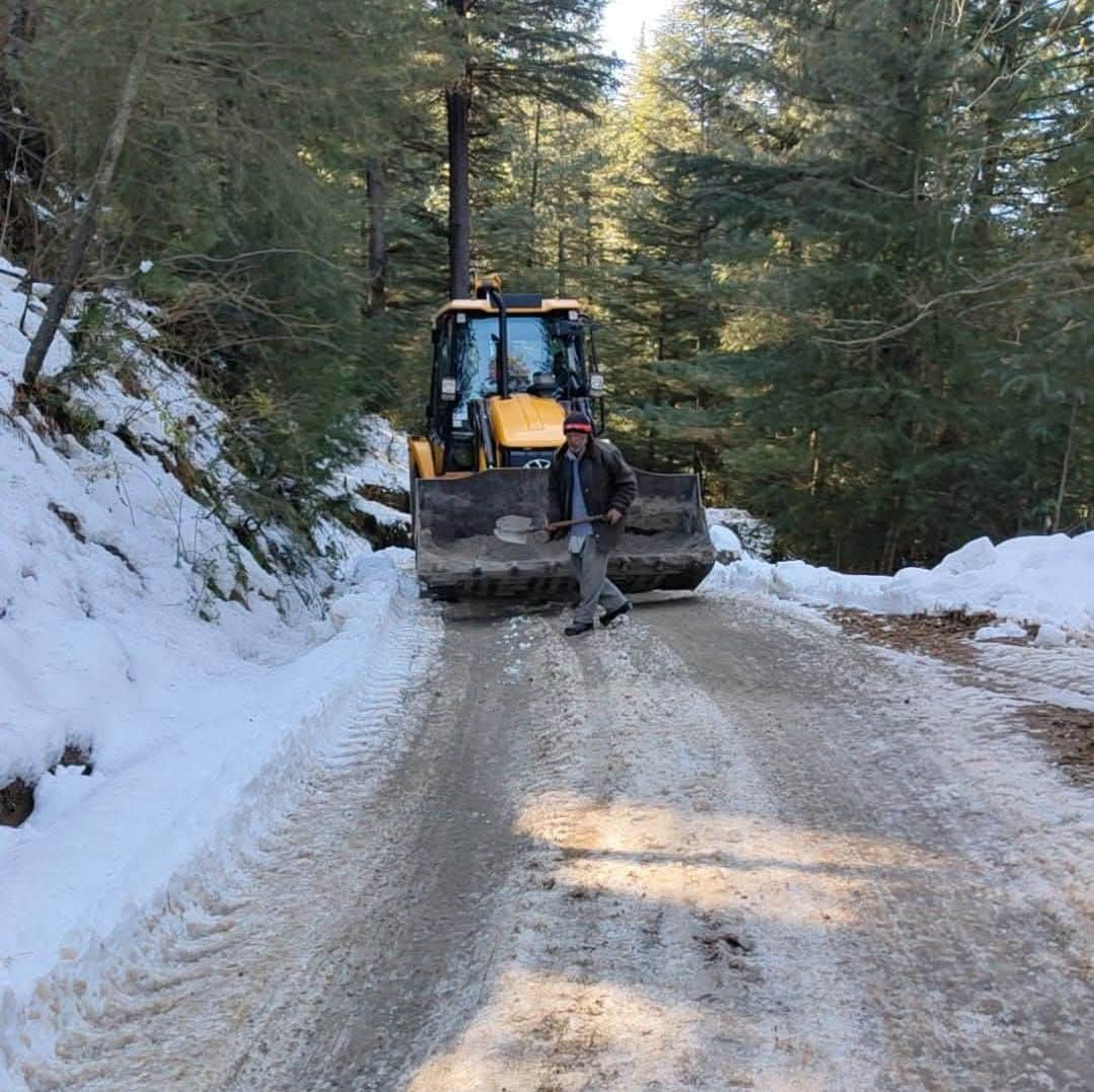 ननखड़ी में सडक़ की बहाली में जुटी मशीन, बर्फ पर रेत बिछाने का कार्य करता मजदूर। संवाद