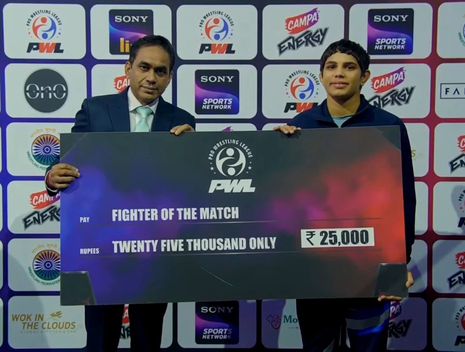 29jjrp22- यूपी डोमिनेटर्स की पहलवान तपस्या गहलावत काे फाइटर ऑफ द मैच का अवार्ड देते अधिकारी। स