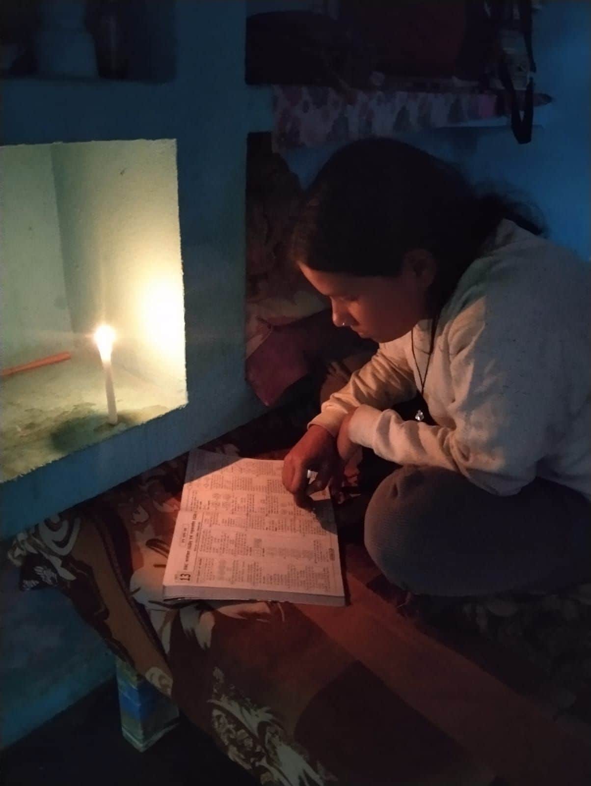 फोटो 1 मोमबत्ती की रोशनी में पढ़ रही छात्रा। संवाद