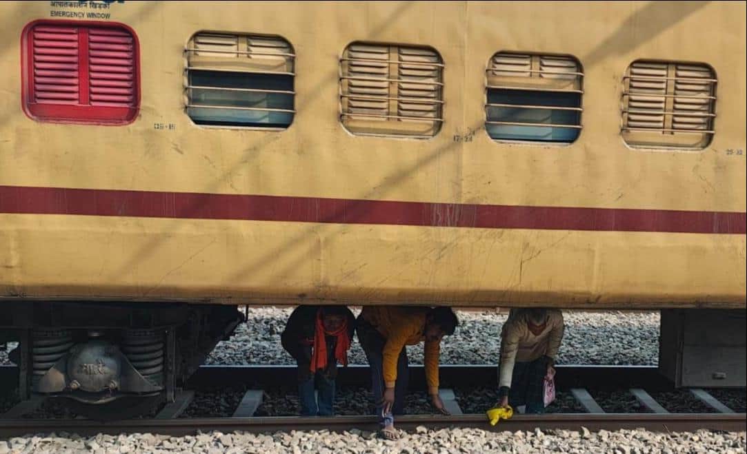 सुरेमनपुर रेलवे स्टेशन परिसर प्लेटफार्म पर खड़ी माघ मेघा स्पेशल ट्रेन के बोगी के नीचे से होकर ग