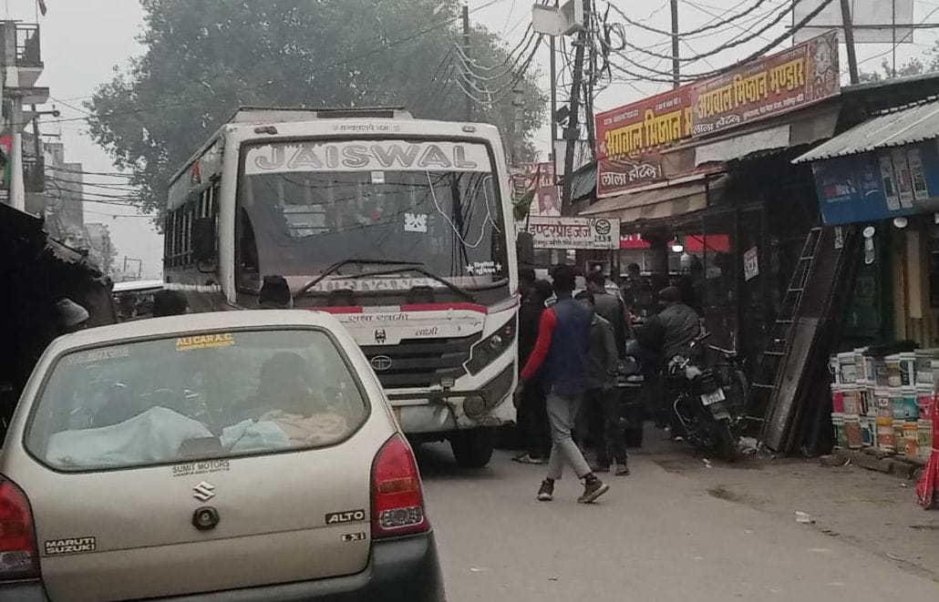 Buses park on the road to pick up and drop passengers, people struggling with traffic jams