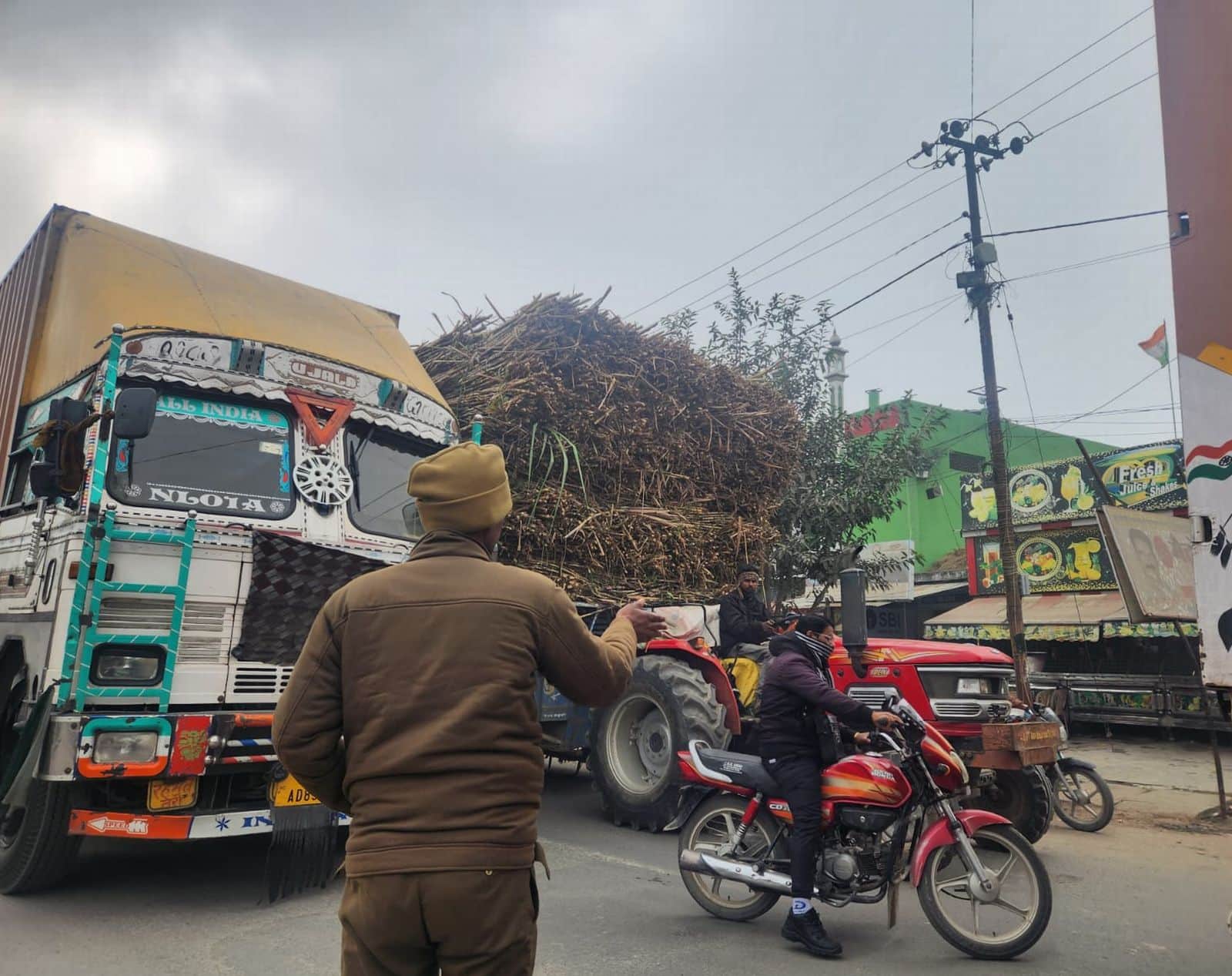 पुलिस के सामने शहर के नवादा चौराहे से जाते ओवरलोड ट्रक व गन्नने से लदे ट्रैक्टश्र-ट्राली।संवाद