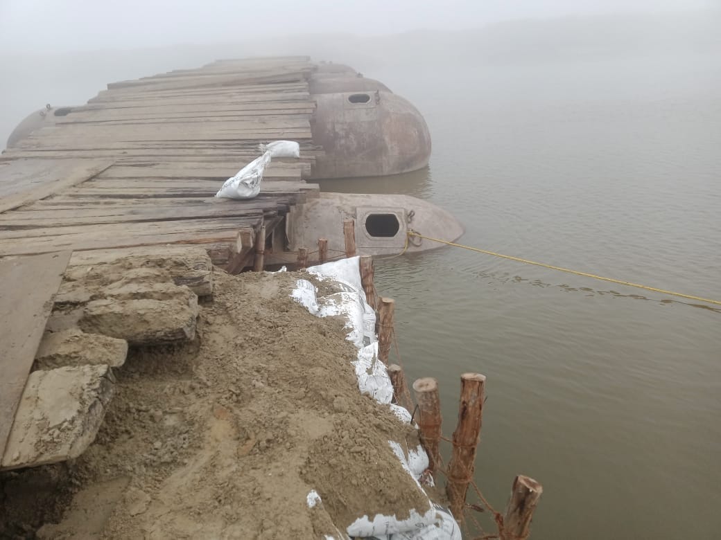 The pontoon bridge is flooded with water, blocking the road at Labheda Ghat.