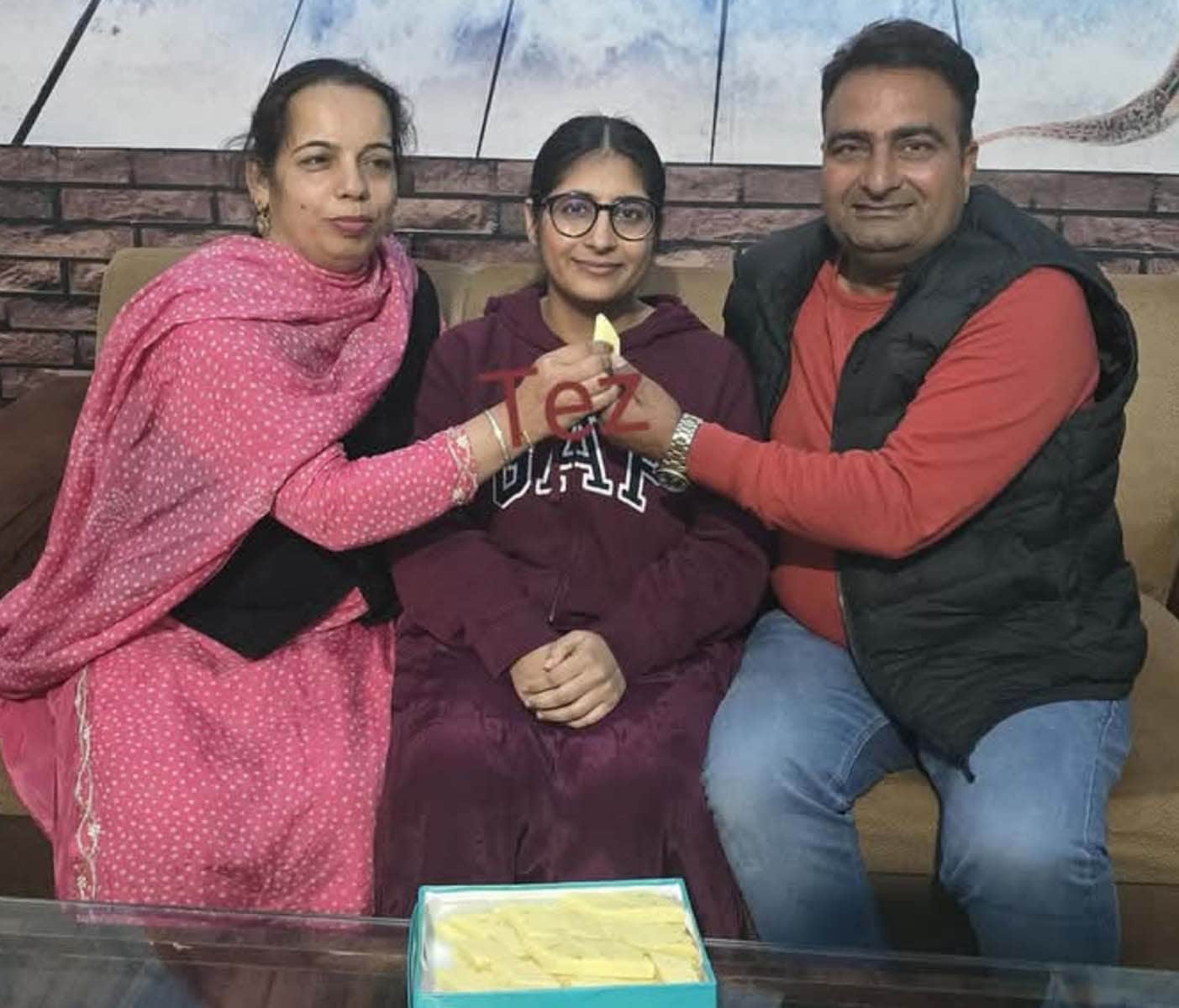 गांव गुटैया निवासी कोमलकौर जोशन को मिठाई खिलाते पिता और मां। स्रोत : स्वयं